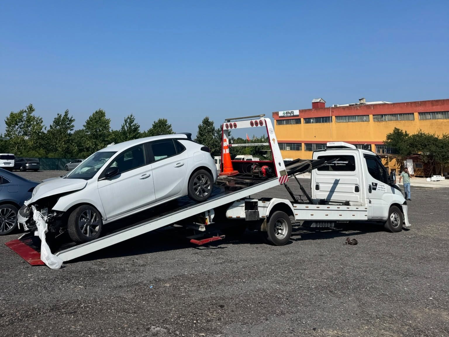 Ön tarafı hasarlı beyaz otomobilin rampa ile kayar kasaya alınması